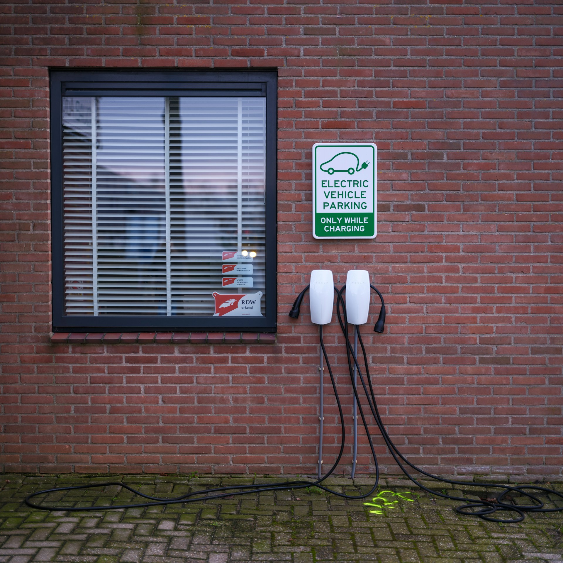 Punto de recarga para vehículos eléctricos instalado en una pared de ladrillo